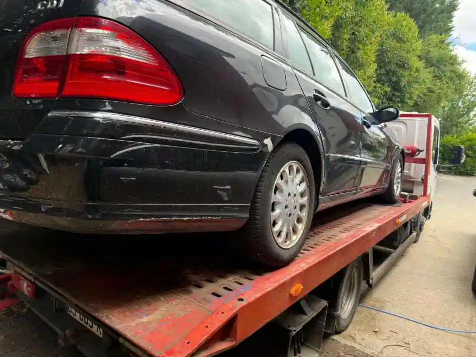 Voiture grise transportée sur une dépanneuse TMB